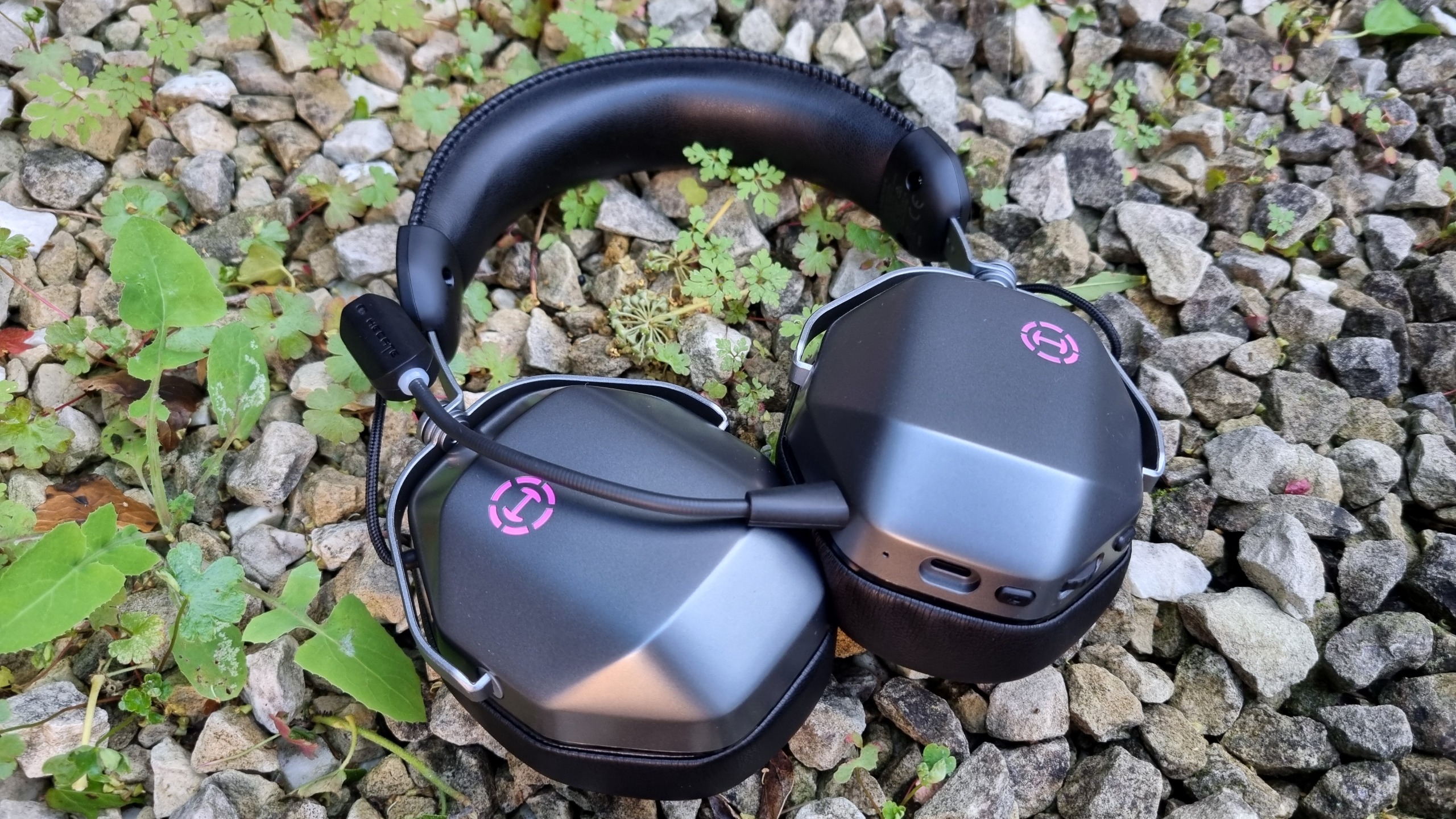 An Edifier G5 Max gaming headset on gravel, surrounded by foliage