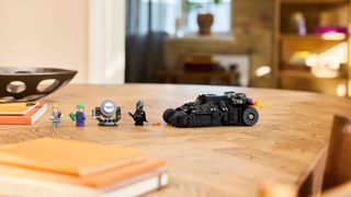 Lego Batman Tumbler vs. Two-Face & The Joker set laid out on a wooden table