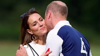 Catherine, Duchess of Cambridge kisses Prince William, Duke of Cambridge during the prize-giving of the Out-Sourcing Inc. Royal Charity Polo Cup