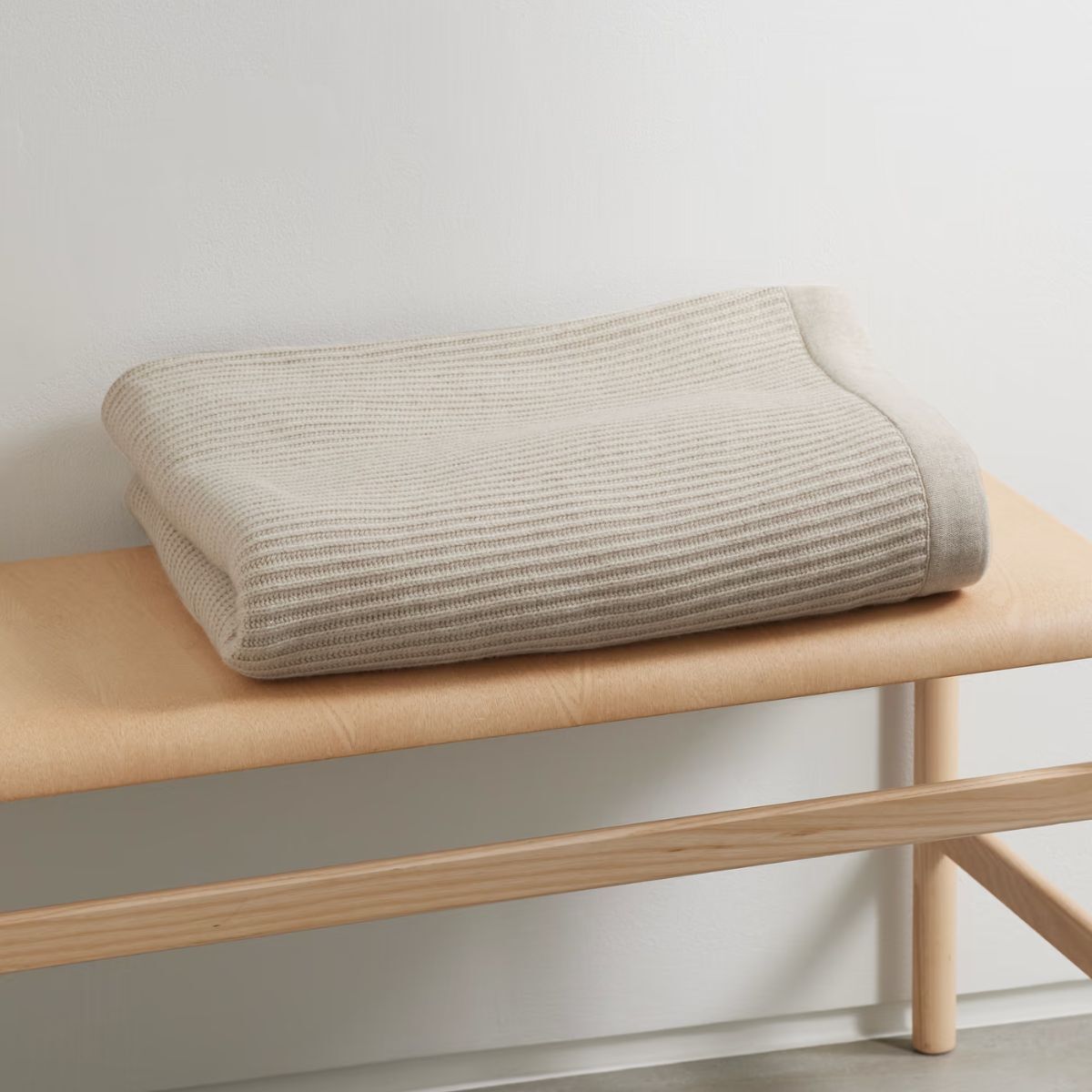 Cream cashmere throw on a bench