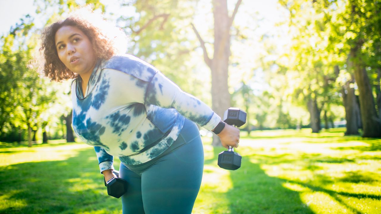 Woman working out with dumbbells outside