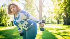 Woman working out with dumbbells outside