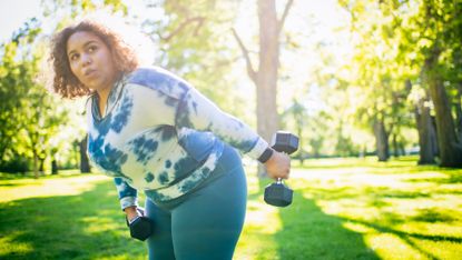 Woman working out with dumbbells outside