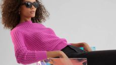 Woman dressed in clothes from Gap - pink jumper, jeans & sunglasses