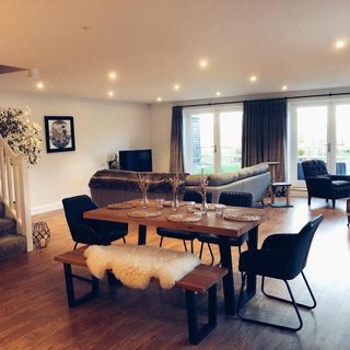 living area with wooden flooring and sofa set and wooden dining table