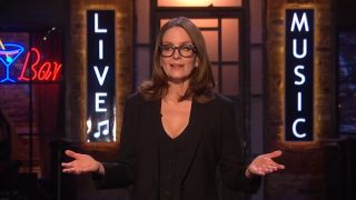 Tina Fey wears a black dress and talks during the monologue on SNL UK.