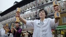 Elderly people exercising with wooden dumbbells in the grounds of a temple in Tokyo on Japan's Respect for the Aged Day