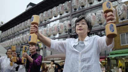 Elderly people exercising with wooden dumbbells in the grounds of a temple in Tokyo on Japan&#039;s Respect for the Aged Day