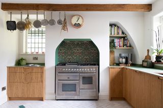 A bespoke kitchen with a range oven wooden cabinets and marble counters