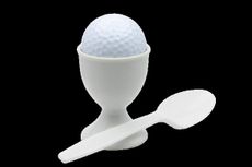 Breakfast ball image of a golf ball perched in an egg cup 