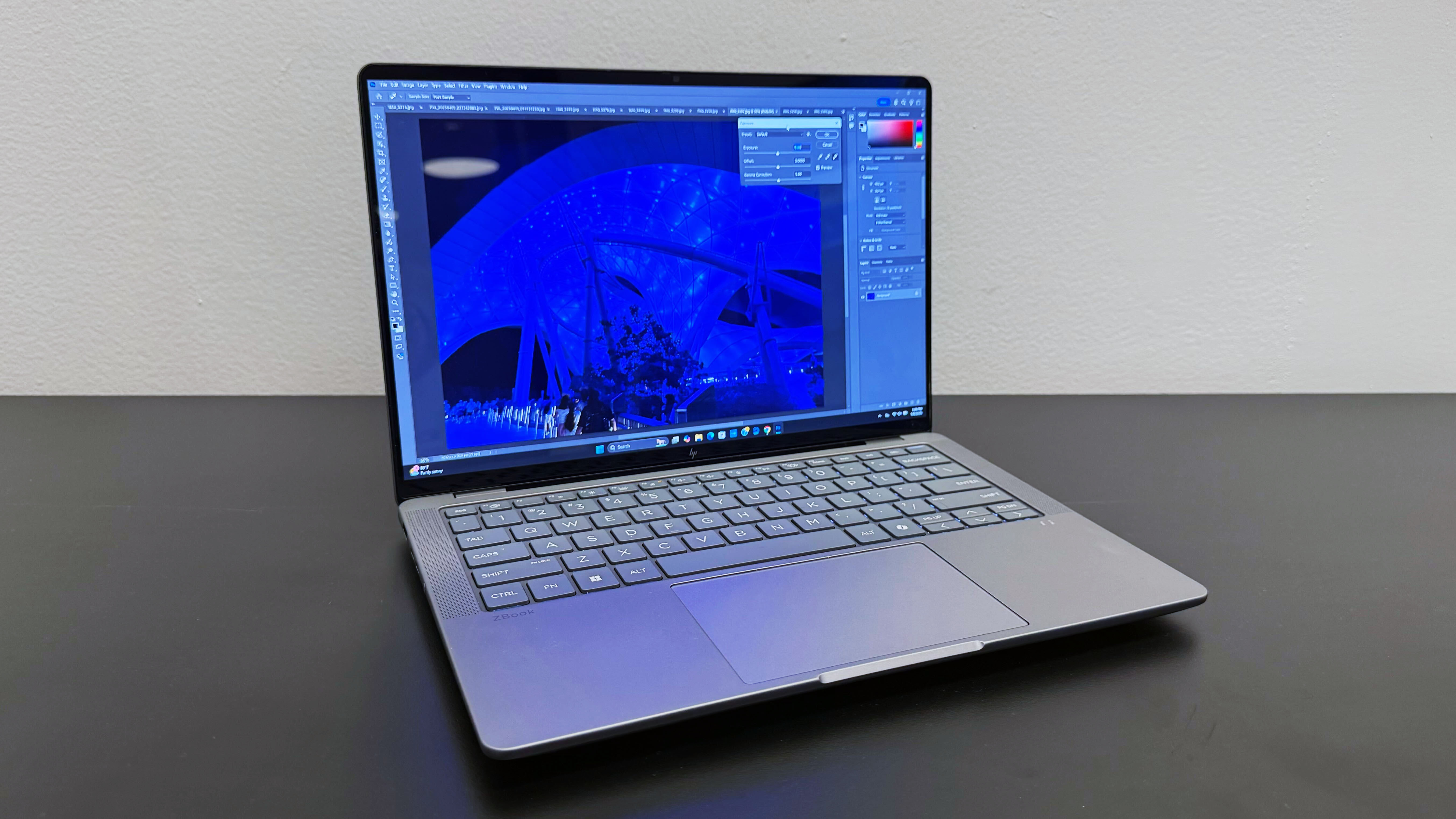 The HP ZBook Ultra 14 G1a mobile workstation open on a black desk against a white wall.