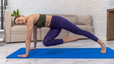 Woman doing the mountain climber exercise at home in front of a couch