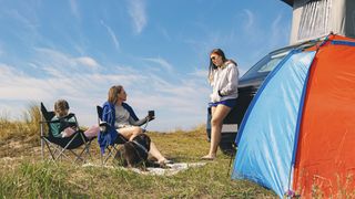 A family camping with a blue and red tent