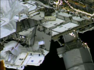 NASA astronaut Chris Cassidy (striped spacesuit) holds an ammonia pump control box during a spacewalk to hunt for an ammonia leak outside the International Space Station on May 13, 2013.