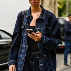 a woman wears a denim jacket
