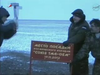 Workers with Russia's RSC Energia company hammer a commemorative sign into place to mark the date and location of the Soyuz TMA-05 capsule landing that returned the Expedition 33 crew to Earth .