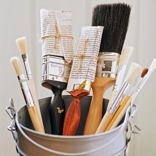painting brushes inside container with white wall
