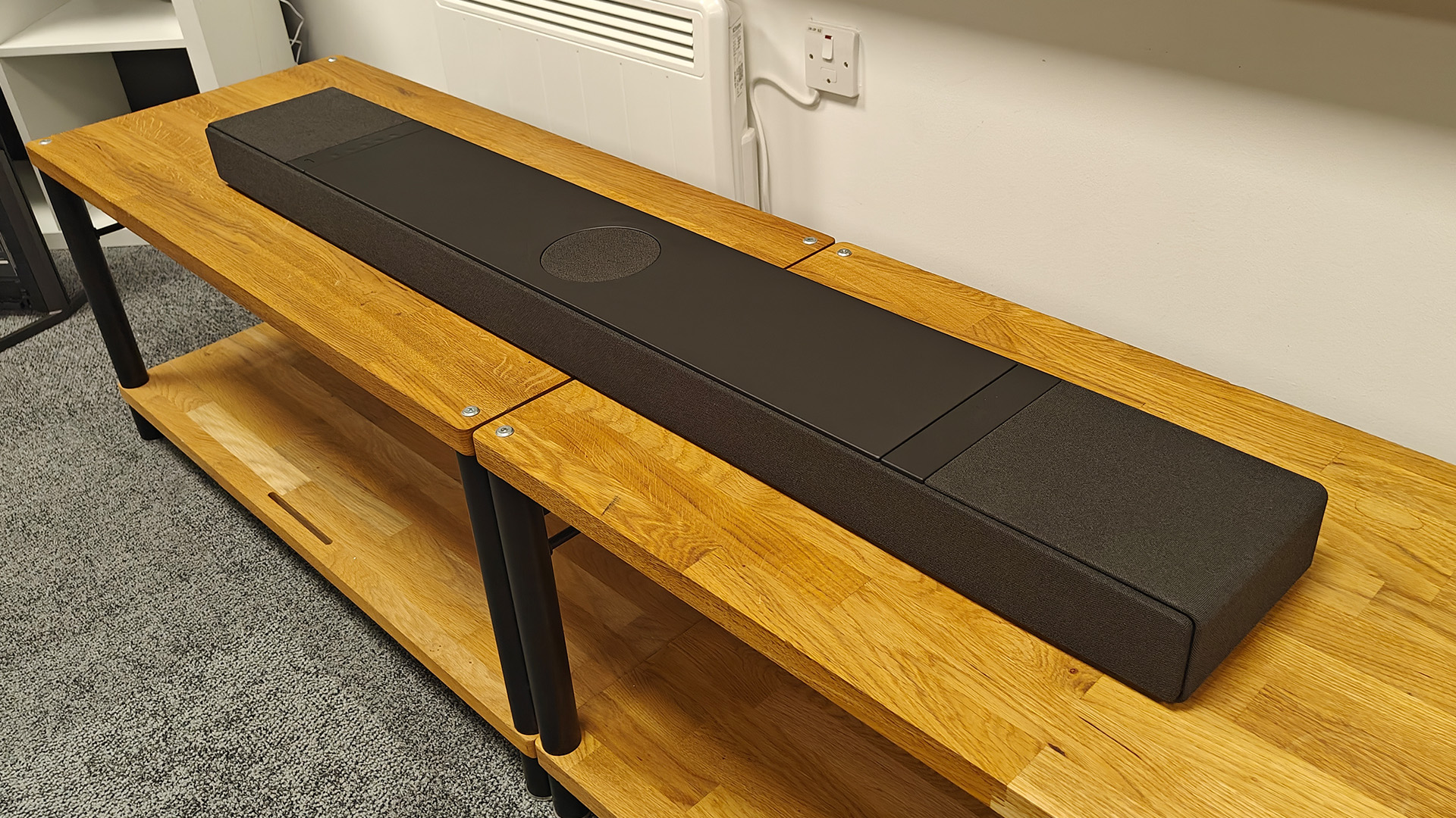 KEF XIO soundbar on wooden AV benches in test room