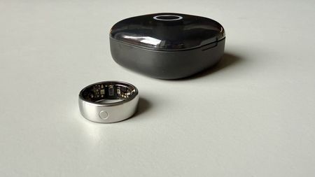 The Circular Ring 2 smart ring pictured next to its charging case on a grey surface.