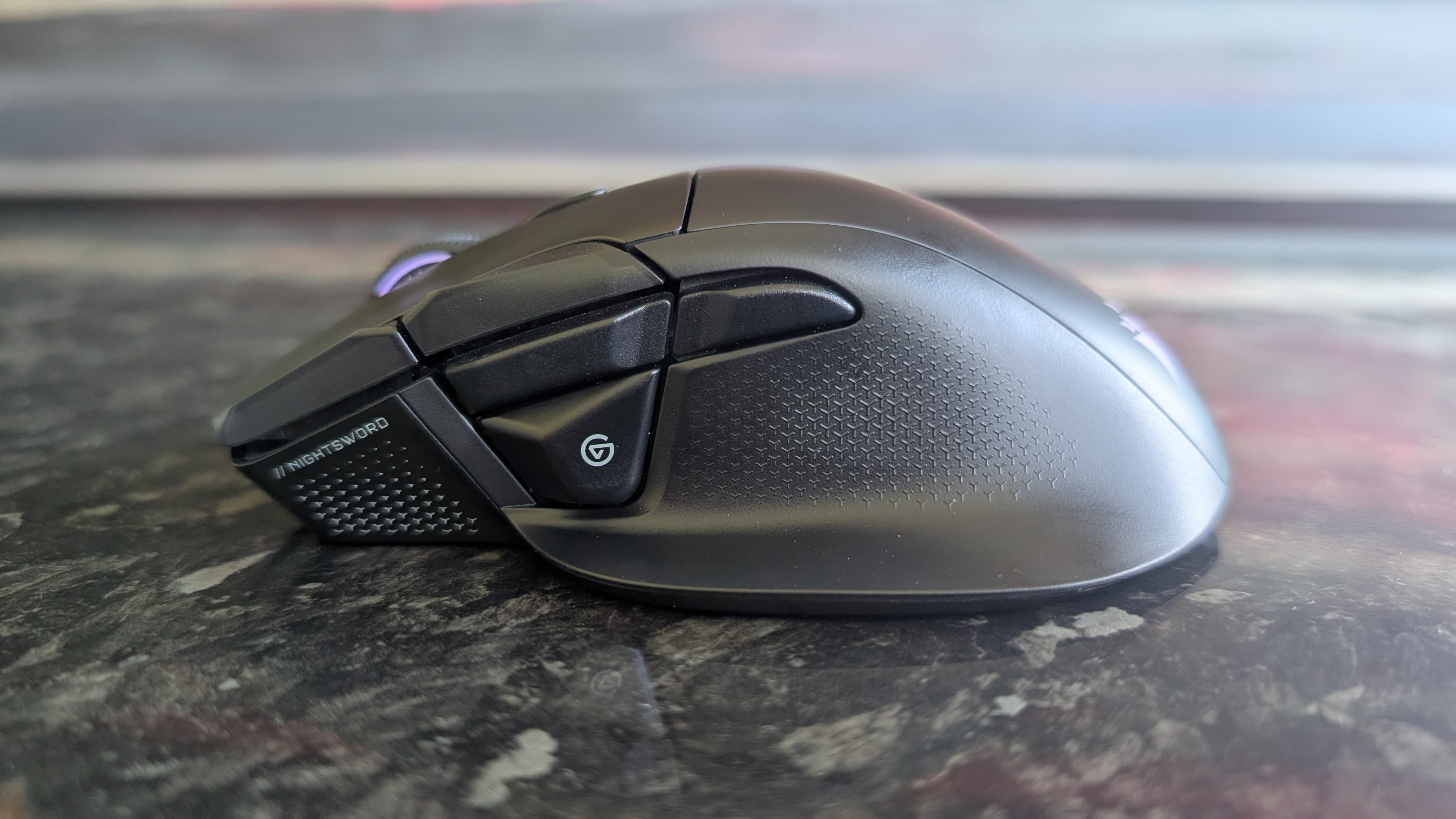 The Corsair Nightsword V2 Wireless gaming mouse pictured on a black marble worktop.