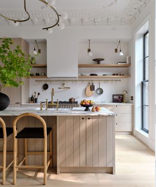 A deVOL, neutral kitchen with high ceilings and an island with marble counters