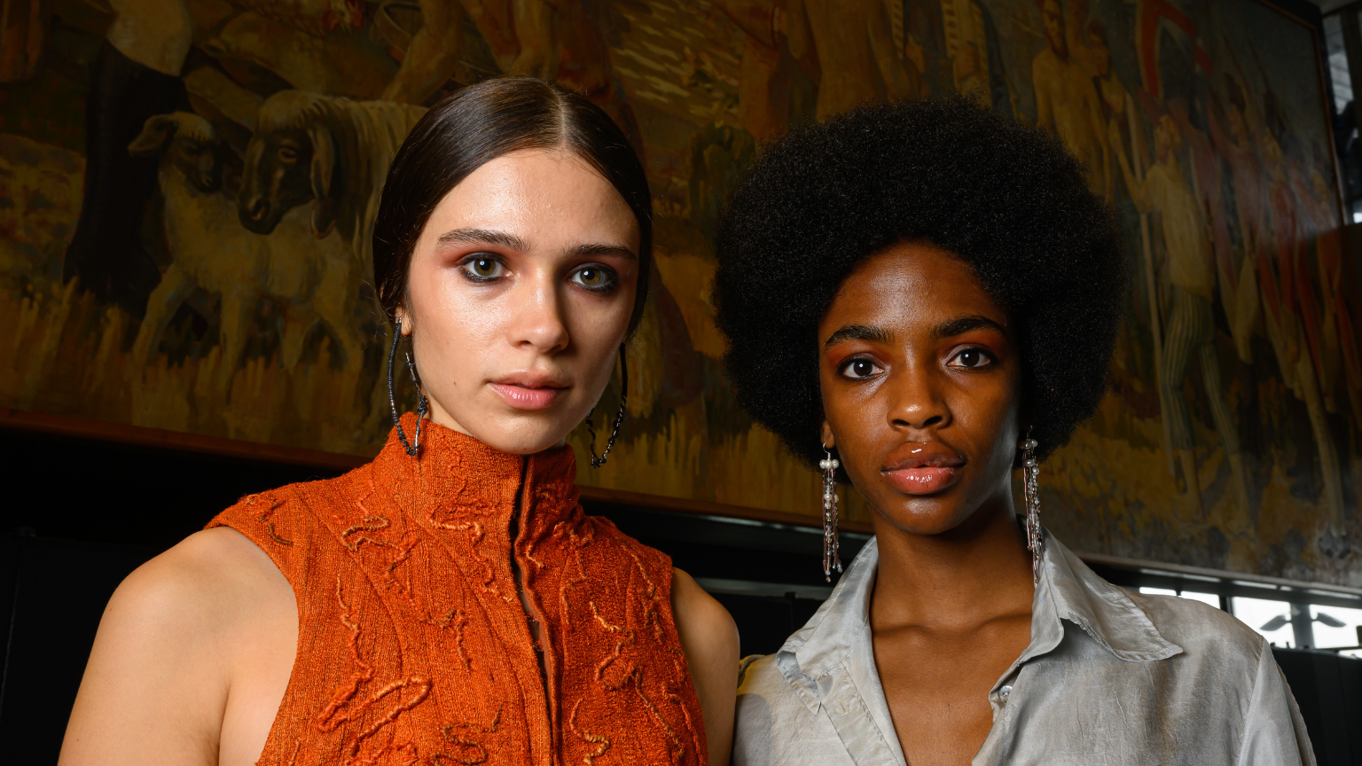 two models backstage with dark eyeshadow