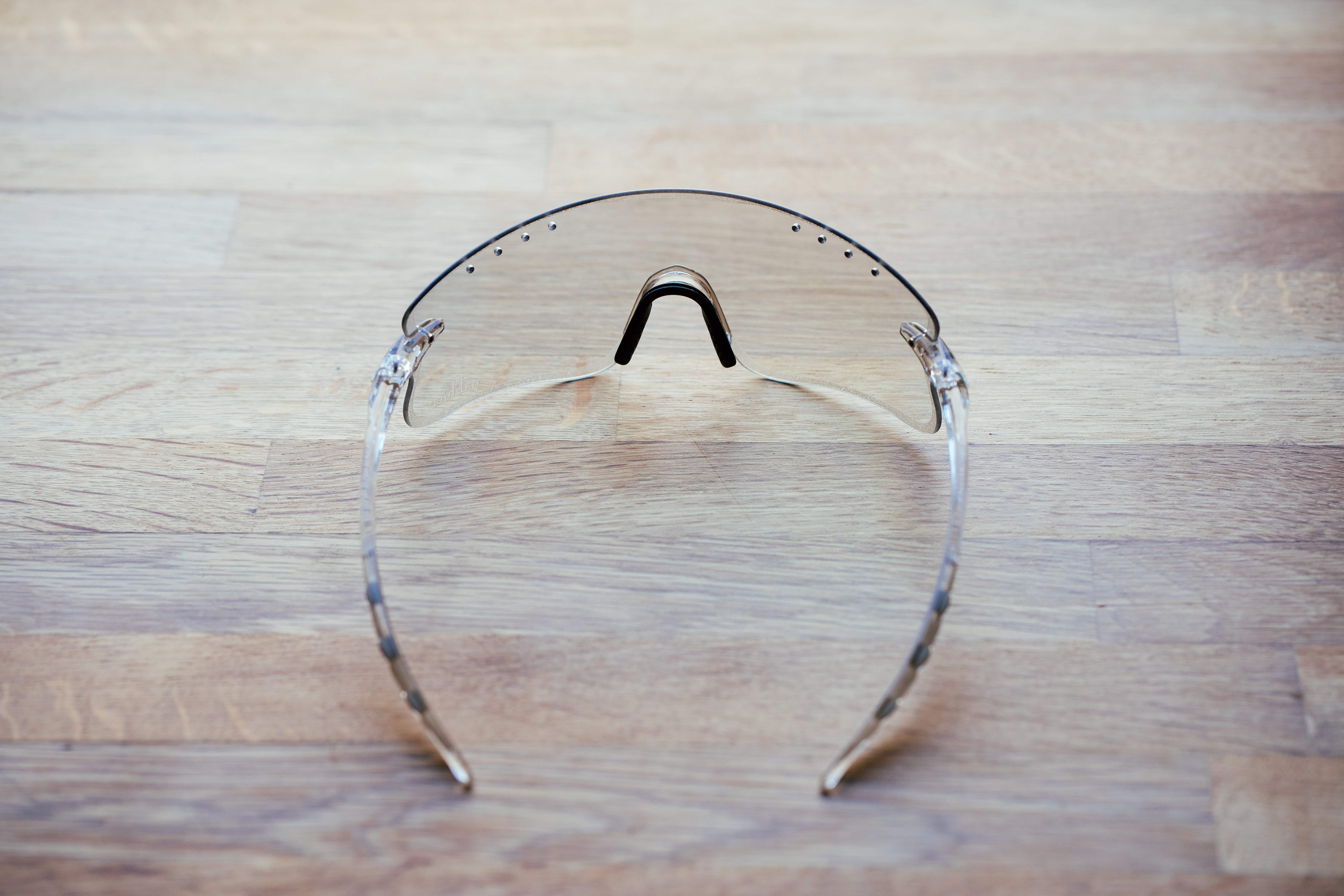 A clear pair of sports glasses on a wooden surface