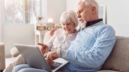 A couple looks at a laptop. 