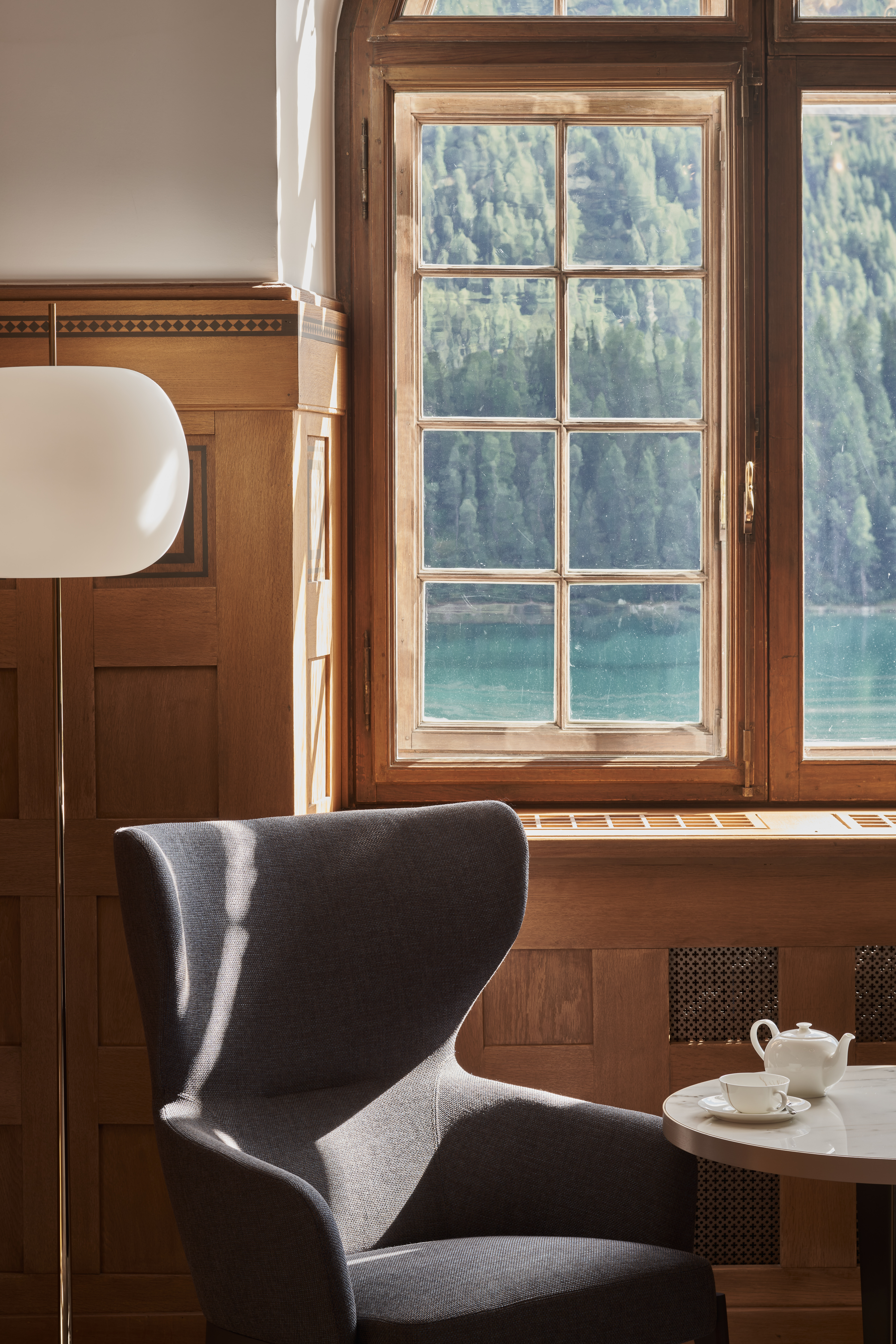 A hotel's scenic setting boasts sun-lit, airy views of the surrounding mountainous nature.