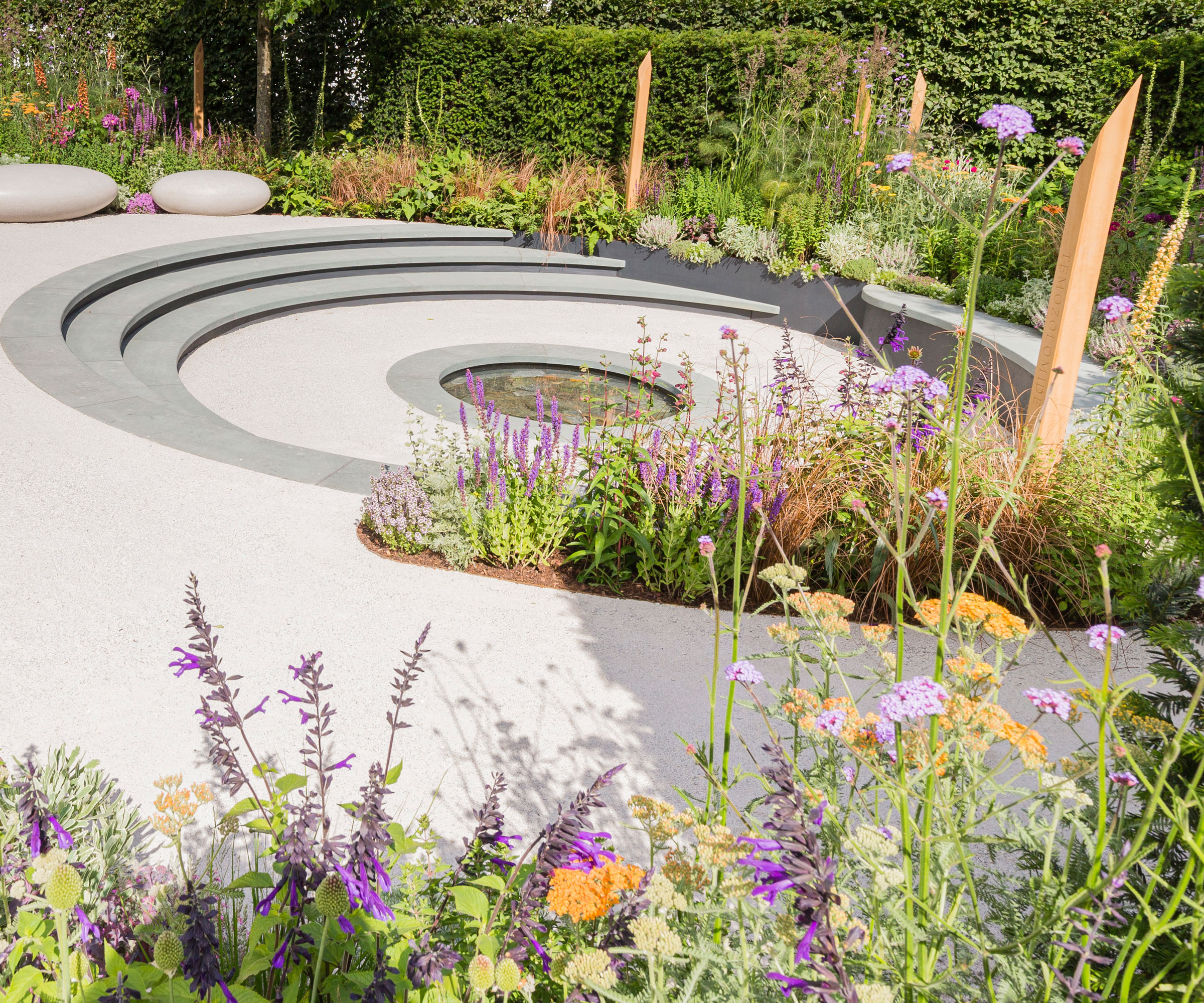 sunken circular patio with planting design and smooth stone seats