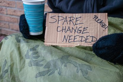 A homeless person asks for change.