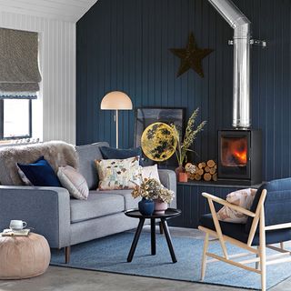 panelled living room with dark blue wall and log burner