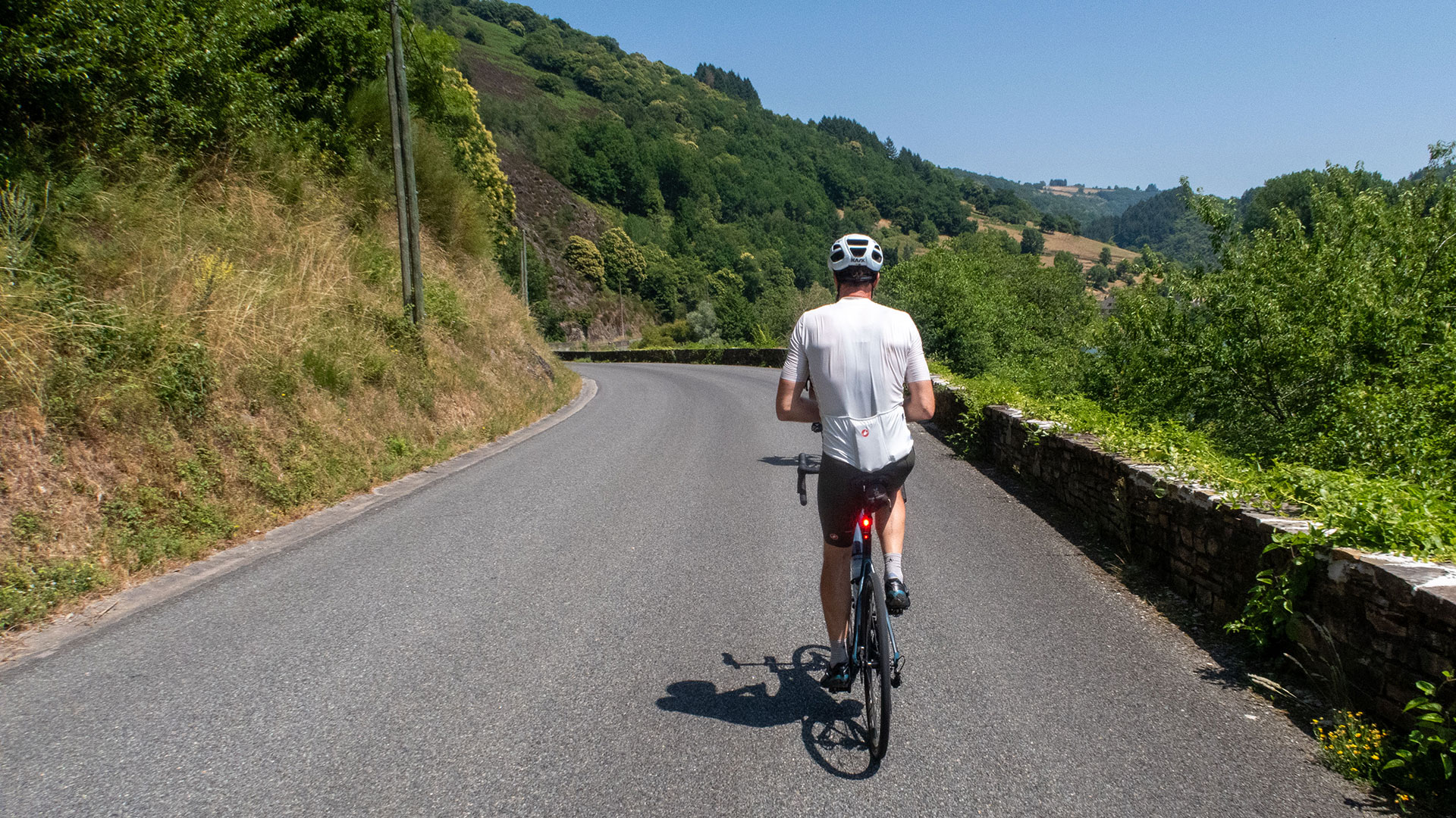 Carefree cyclist riding down rural road with radar