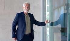 An older businessman at the door of his office