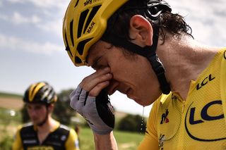 Great Britain's Geraint Thomas cleans his eyes after tear gas was used during a farmers' protest who attempted to block the stage's route
