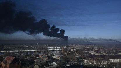 Black smoke rises above a military airport in Chuguev in eastern Ukraine