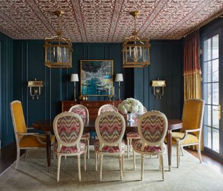 Blue panelled walls and yellow chairs and curtains and golden lampshades