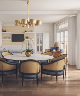 dining room in neutral palette with gold pendant light and cane backed chairs and wooden floor