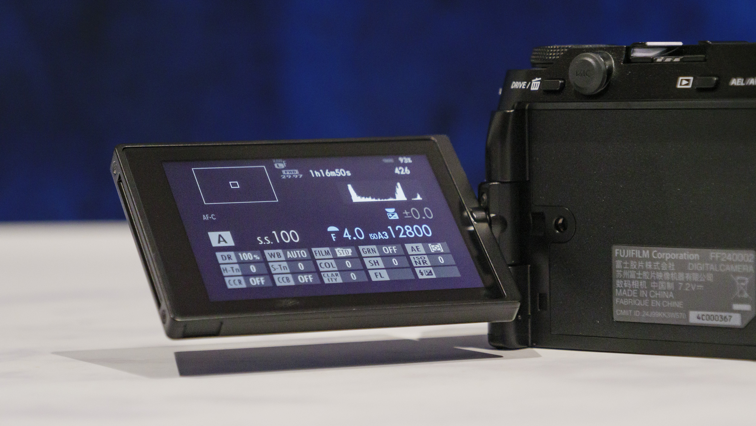 Closeup of the Fujifilm X-M5 camera's flip screen, on a marble surface with rich blue background