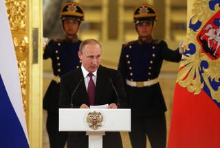 Russian President Vladimir Putin addresses the Russian Olympic team in July.
