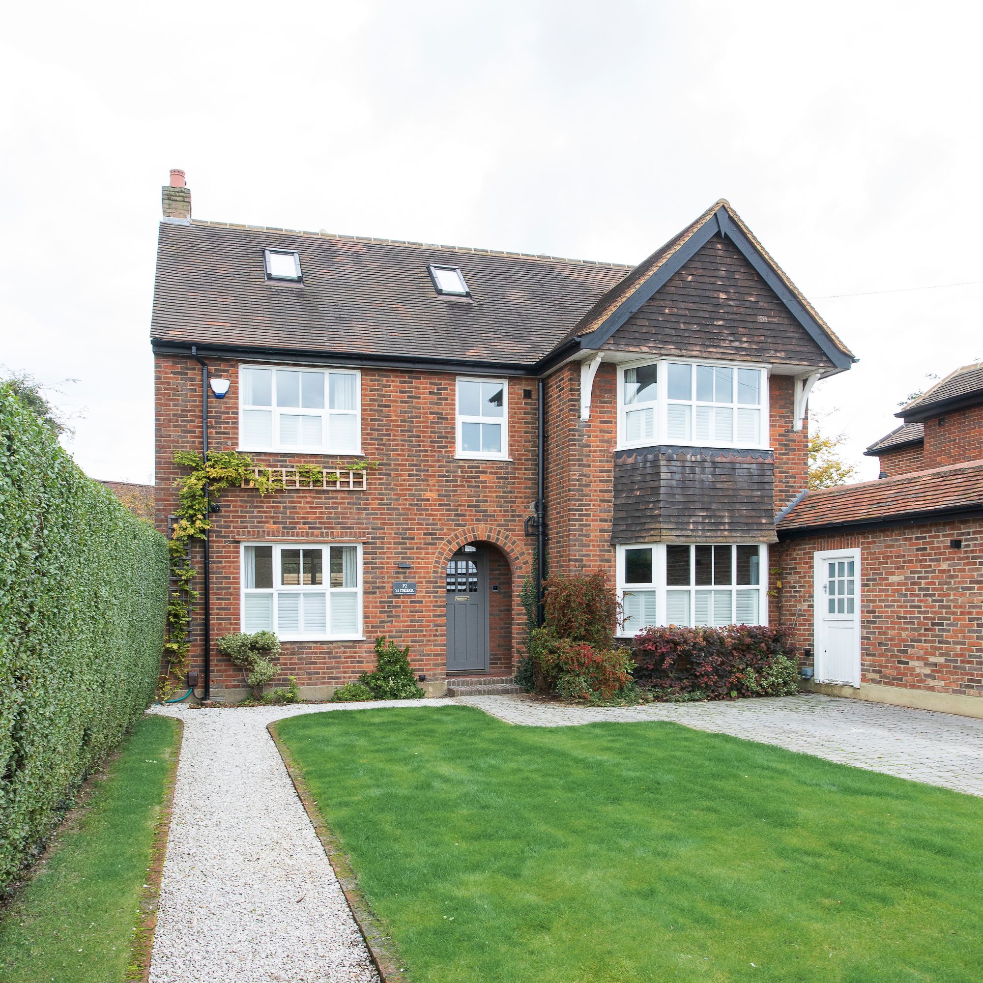 Gravel drive and pathway, and front lawn, leading up to brick property