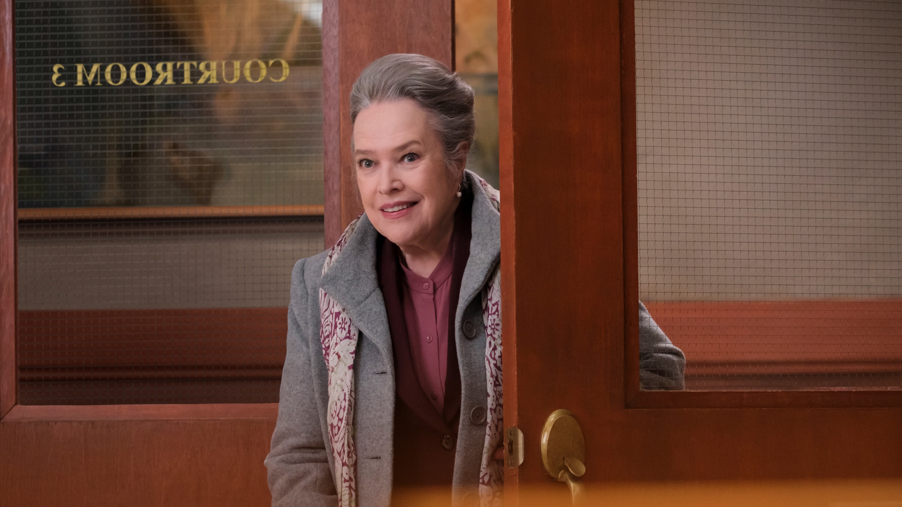 Kathy Bates as Madeline Matlock looking through a courtroom door in Matlock