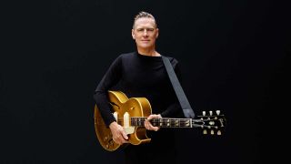 Bryan Adams with a semi-acoustic guitar