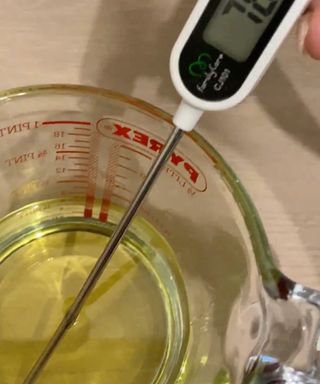 melted wax in a pyrex jug with thermometer