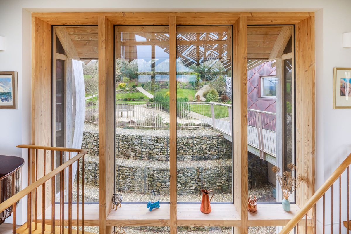 The timber frame window shows the tiered stone garden structure