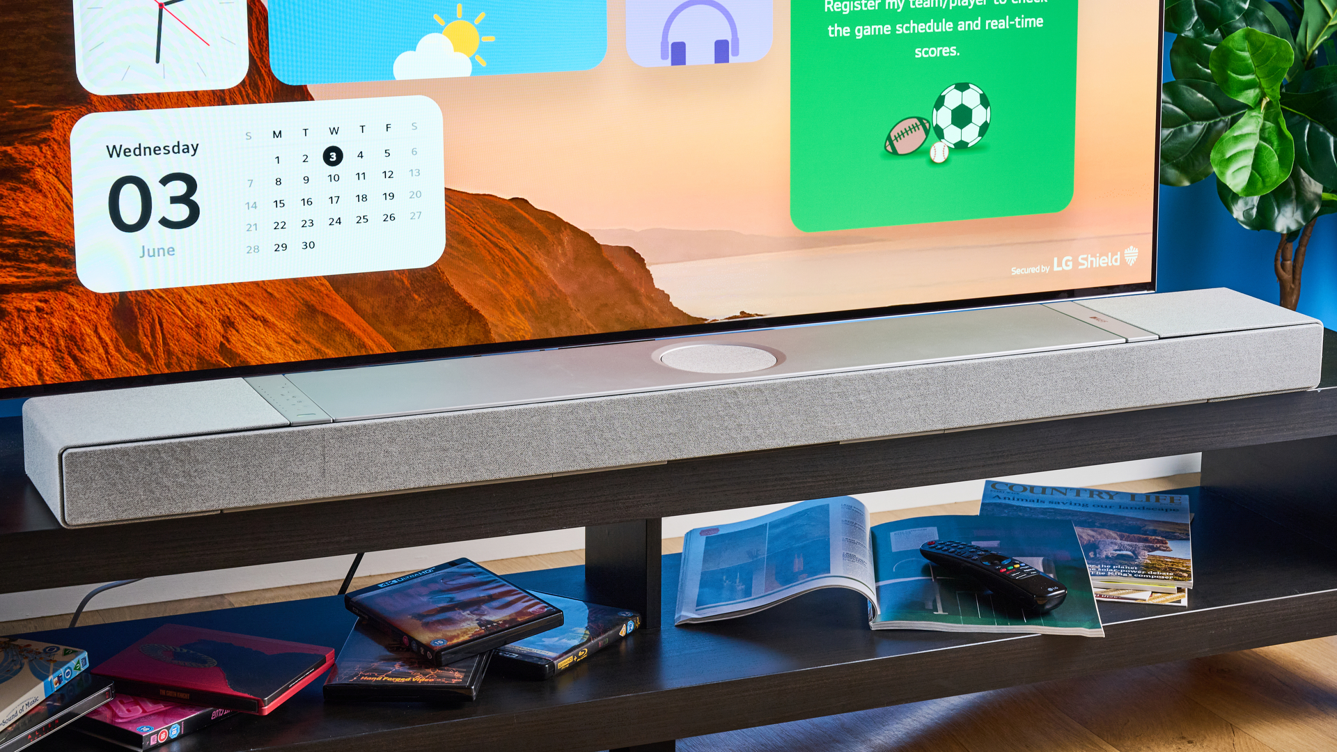 the KEF XIO soundbar in gray photographed with a TV and the Tom's Guide blue background