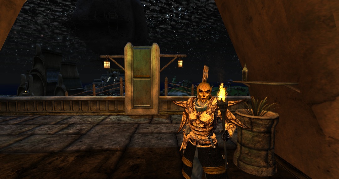 An Ordinator stands with a torch on the highest level of a canton in Vivec.