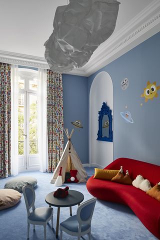 blue playroom with cloud light, blue carpet, red sofa, mini chairs and table, teepee, alphabet drapes