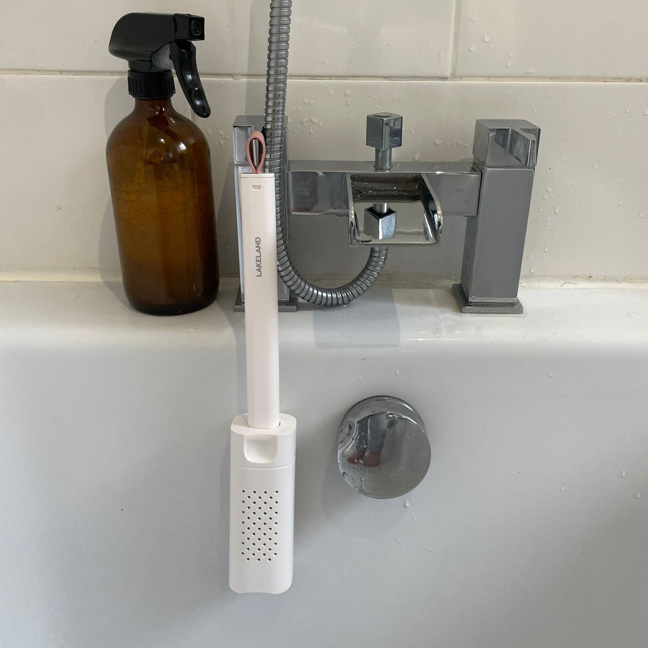 Lakeland mini window mop hanging from bathroom taps in a bath