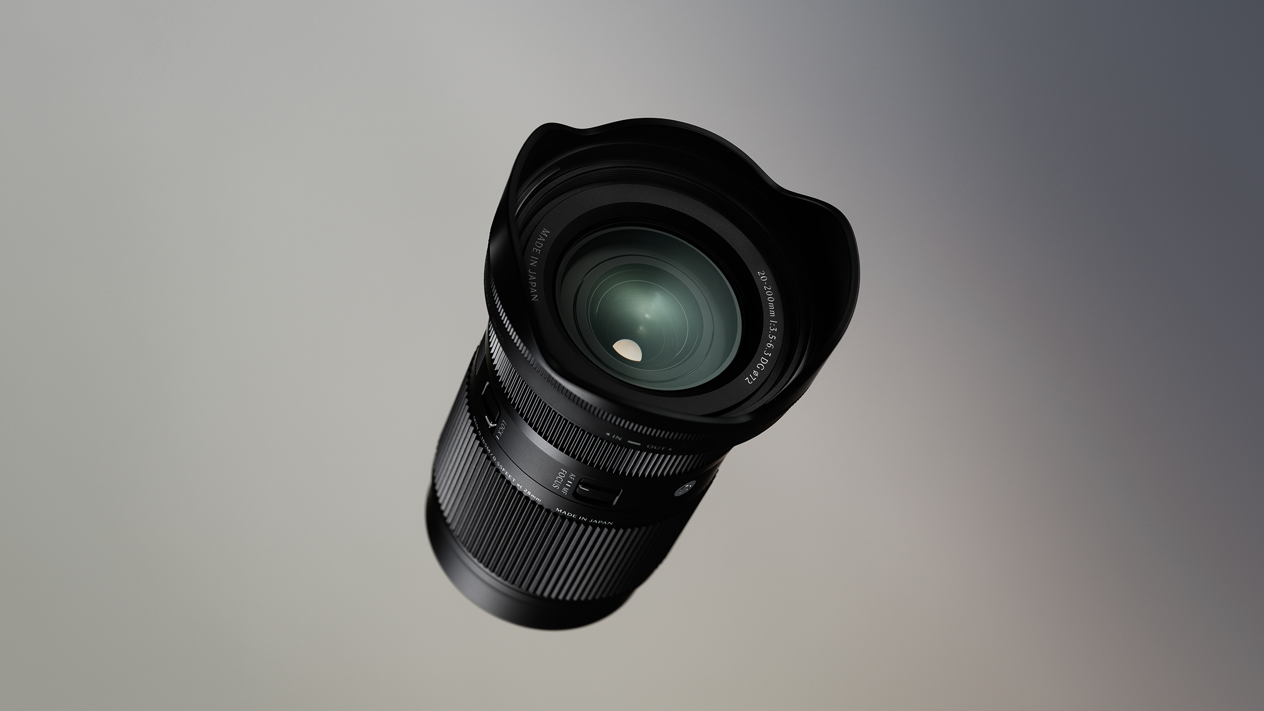 Sigma 20-200mm F3.5-6.3 DG | Contemporary with a wide hood against a gradient gray background, creating a sleek and professional tone